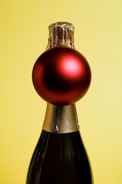 Foto una botella de champagne navideño con una bola roja