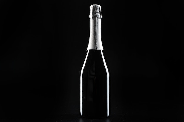 Botella de Champagne sobre fondo negro oscuro de cerca