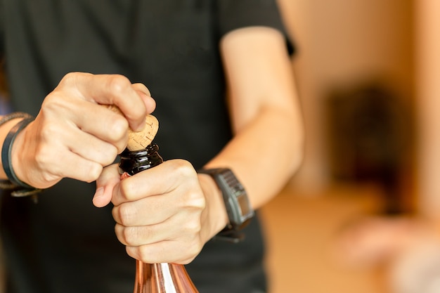 Botella de champán de apertura de mano para celebración en interiores.