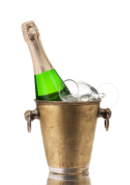 Botella de champán en un balde vintage con hielo y vidrio