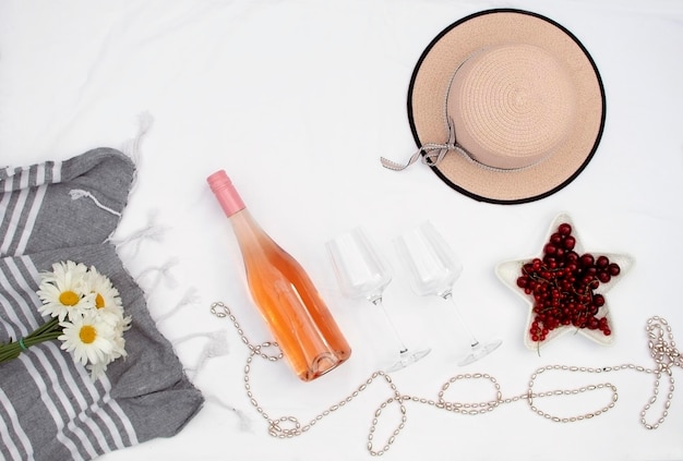 Botella de champán rosado con copas de cristal vino espumoso con luz del día Bebida alcohólica de verano con un pequeño ramo de flores Vista superior concepto de romance de verano