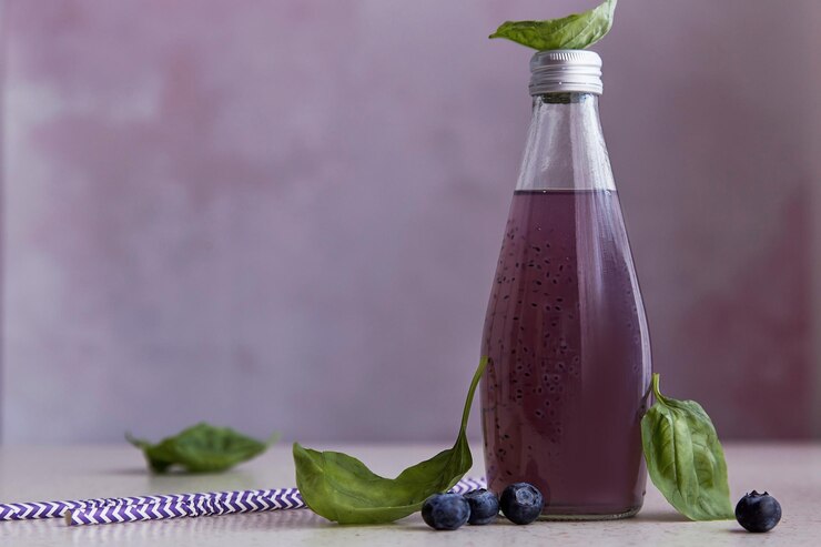 Foto botella de cóctel púrpura orgánico refrescante con semillas de arándanos hojas de extracto de albahaca bebida asiática saludable de verano primer plano borroso