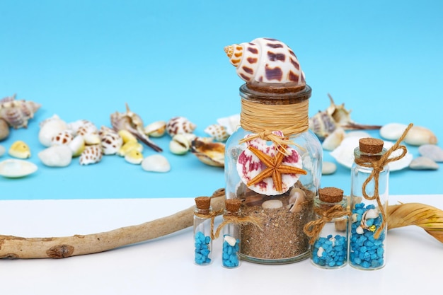 Una botella de conchas y una concha de mar con una estrella de mar.