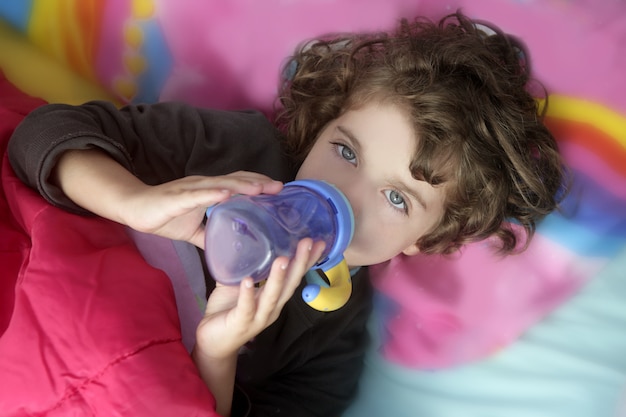 Botella de consumición de la niña adorable