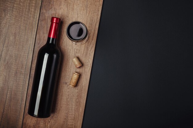 Botella de corchos de vino y copa de vino sobre fondo oxidado