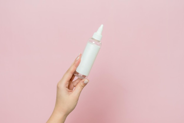 Botella cosmética en la mano de la mujer Maqueta de marca de producto cosmético Concepto de tratamiento de belleza Spa