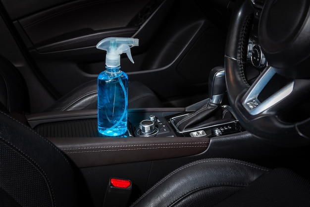 Botella de desinfectante azul, alcohol etílico, gel limpiador para manos, colocado dentro del automóvil.
