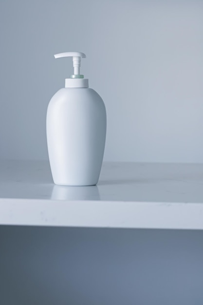 Botella de envase cosmético de etiqueta en blanco como maqueta de producto sobre fondo gris