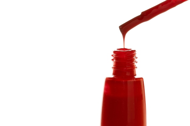 Botella de esmalte de uñas rojo aislado sobre fondo blanco.