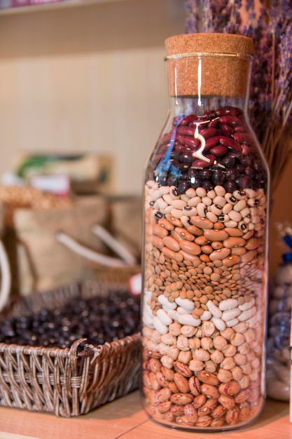 Una botella de frijoles y otros granos está llena de frijoles y otros granos.