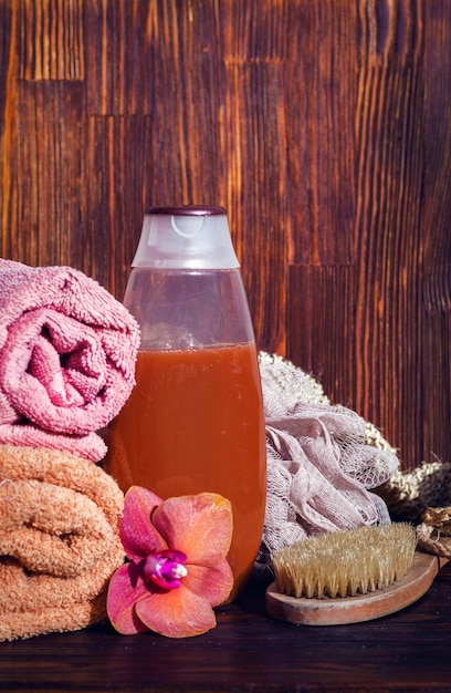 Botella de gel de ducha en la mesa entre accesorios de baño