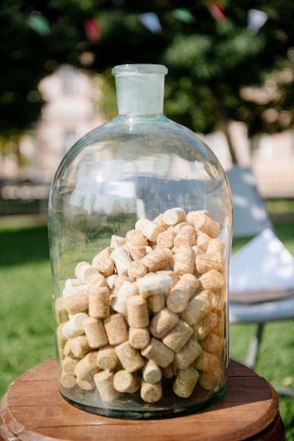 Botella grande de vidrio transparente con corchos de madera en el interior