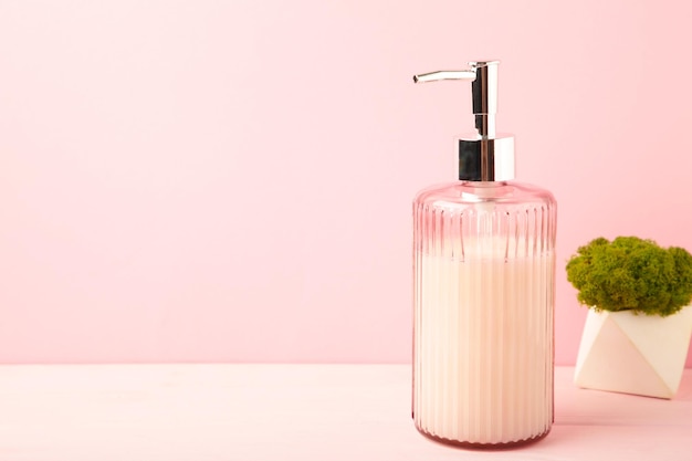 Foto botella de jabón para accesorios de baño sobre un fondo rosado