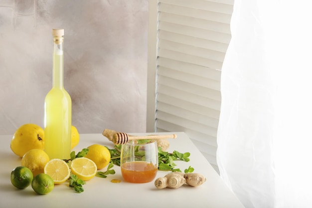 Botella de jugo casero con jengibre y limón sobre fondo claro Horizontal