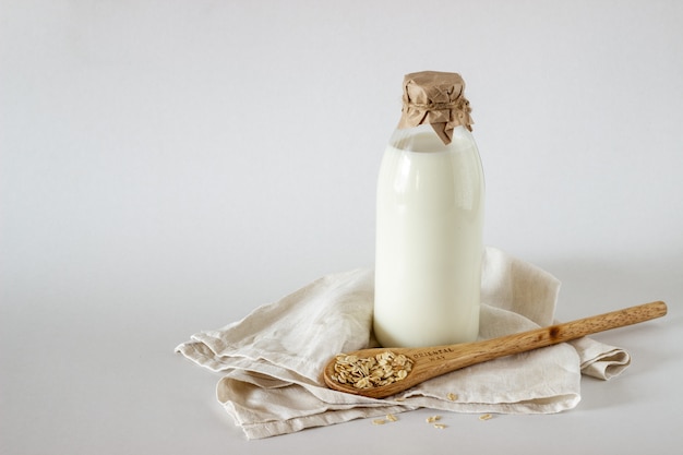 Foto una botella de leche y una cuchara de avena.