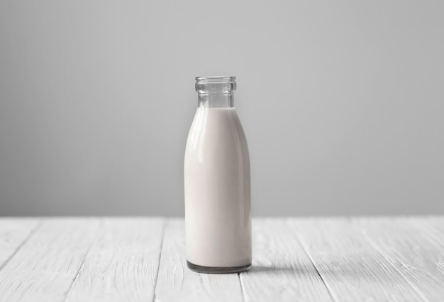 Botella de leche fresca en una mesa blanca de madera
