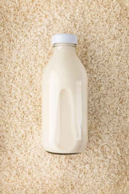 Botella de leche sin lactosa de arroz vegetal sobre arroz