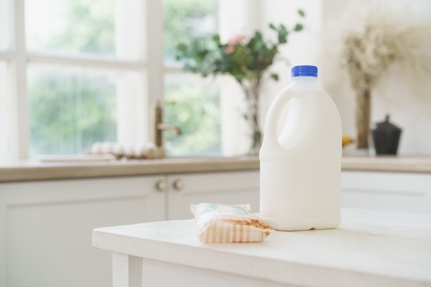 Botella de leche en la mesa de la cocina de madera blanca