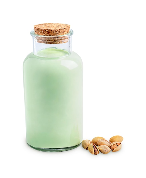 Botella de leche de pistacho sin lactosa fresca servida en botella de vidrio con un montón de nueces en blanco