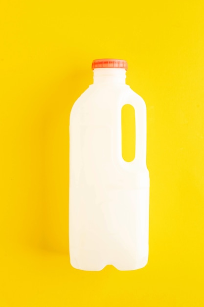 Botella de leche de plástico biodegradable sin marcar sobre un fondo amarillo concepto de residuos cero de productos lácteos