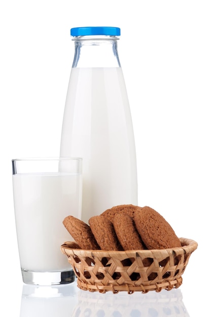 Botella de leche y vaso con galletas aisladas sobre fondo blanco