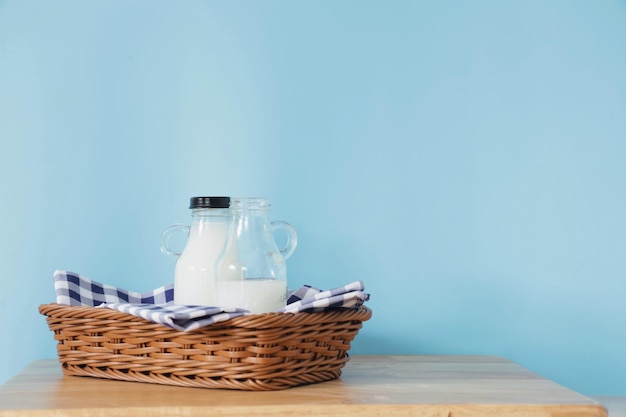 botella de leche y un vaso sobre una mesa de madera.