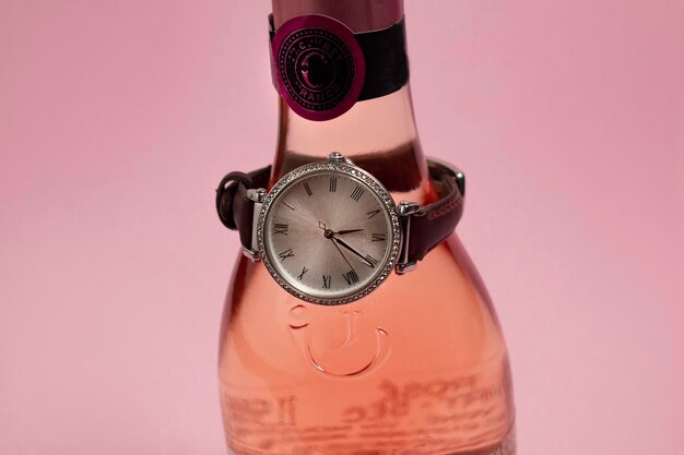 Una botella de licor rosa con un reloj