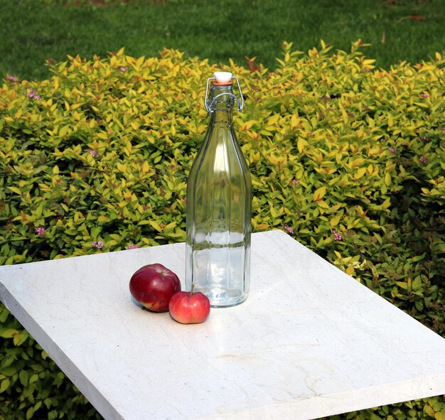 Botella y manzana en la mesa de mármol.