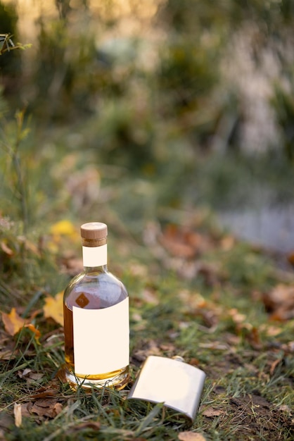 Botella y matraz en el césped en un picnic