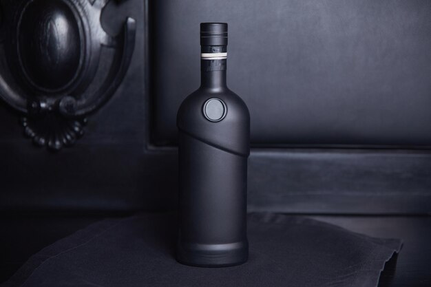 Una botella negra de vino sin etiqueta sobre un fondo oscuro Alcohol de élite en el interior Hermoso fondo