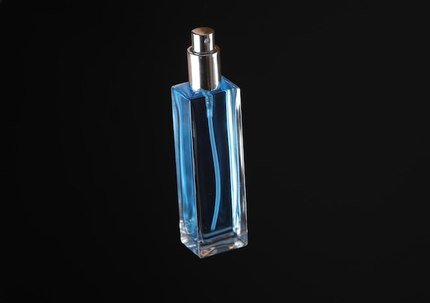 Botella de perfume aislado sobre fondo negro
