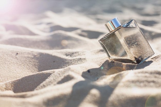 Foto botella de perfume en la arena