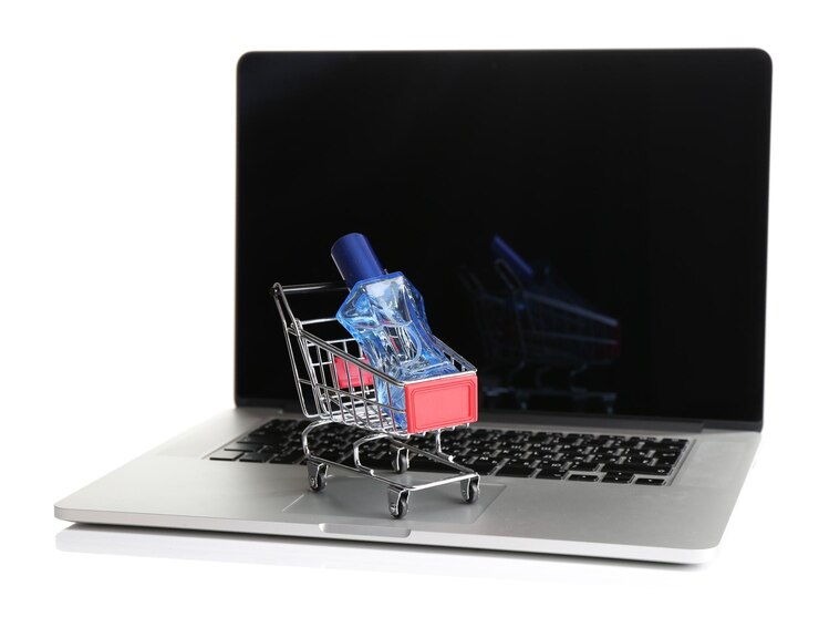 Foto botella de perfume en el carrito de compras en una computadora portátil aislada en blanco