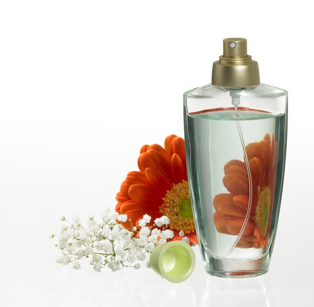 Foto botella de perfume y decoración floral