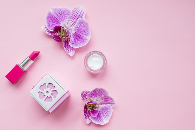 Botella de perfume femenino y delicadas flores de orquídeas