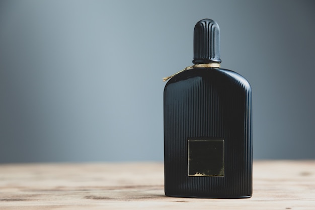 Botella de perfume de hombre negro sobre el escritorio