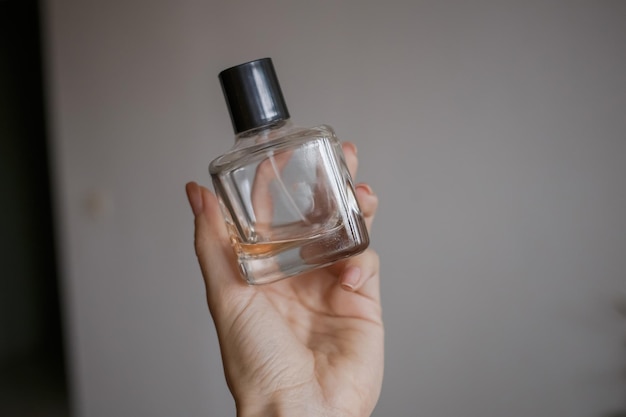 Una botella de perfume en manos de una niña.