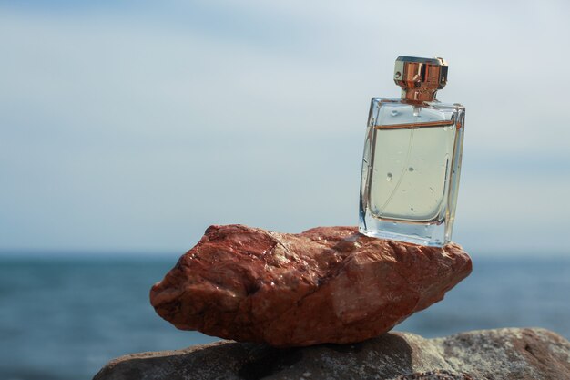 Botella de perfume de mujer en el fondo del mar