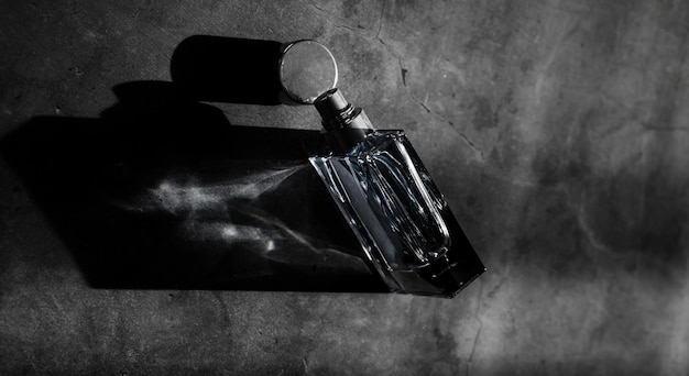 Foto botella de perfume sobre fondo oscuro