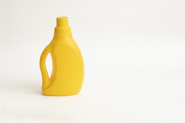 Botella plástica amarilla para detergente sobre fondo blanco
