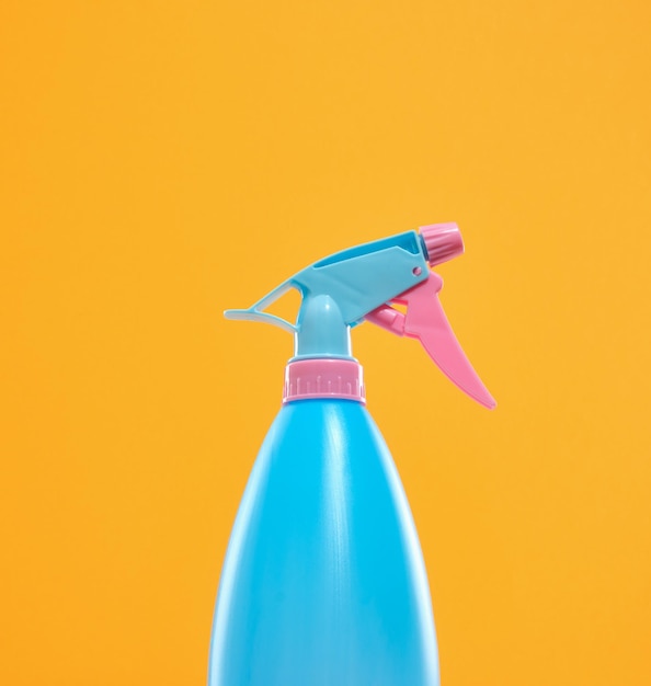 Botella de plástico con agua para limpieza y limpieza de la casa de color azul brillante y rosa Lavado de ventanas y espejos Concepto de limpieza