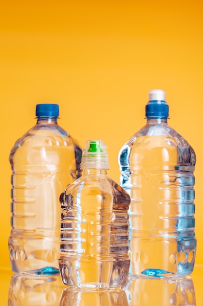 Botella de plástico de agua mineral sobre un fondo amarillo brillante