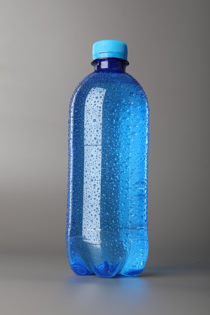 Botella de plástico de agua sobre un fondo gris
