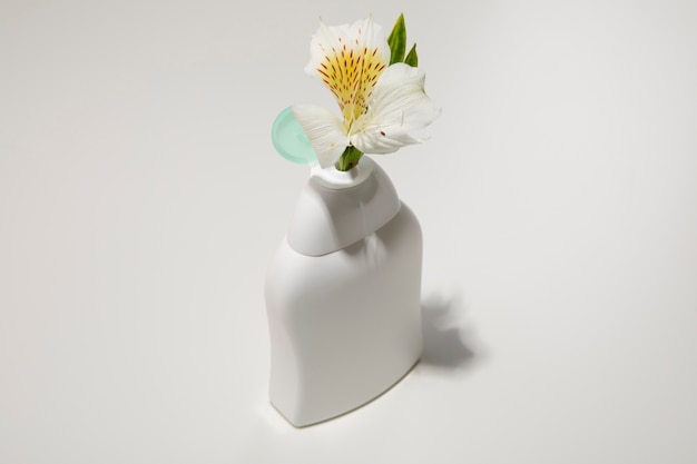 Botella de plástico de alto ángulo con flor.