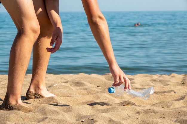 Una botella de plástico está en la playa dejada por un turista.