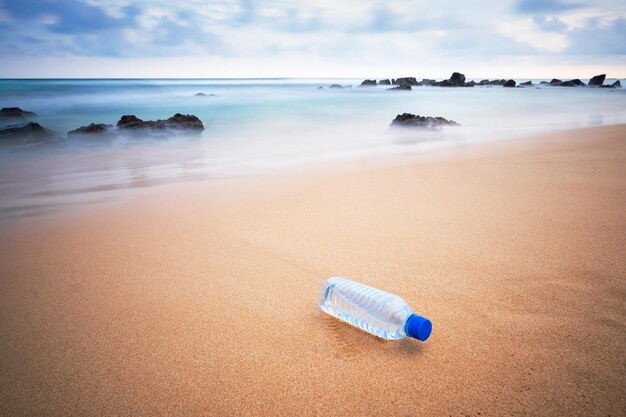 Foto botella de plástico en la playa