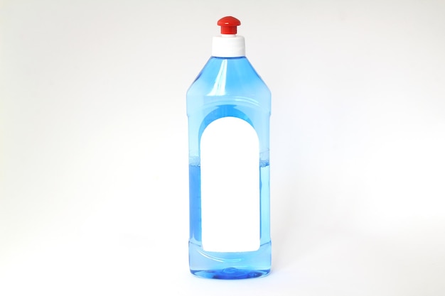 Botella de plástico transparente con detergente en boquilla verde para el hogar, maqueta vacía aislada sobre fondo blanco.
