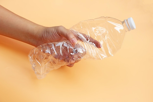 Botella de plástico vacía con la mano