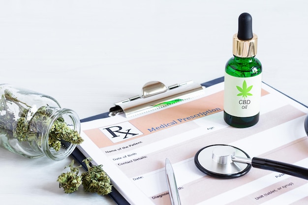 Botella de semillas de cannabis de aceite de Cbd y hojas secas sobre hoja de prescripción médica