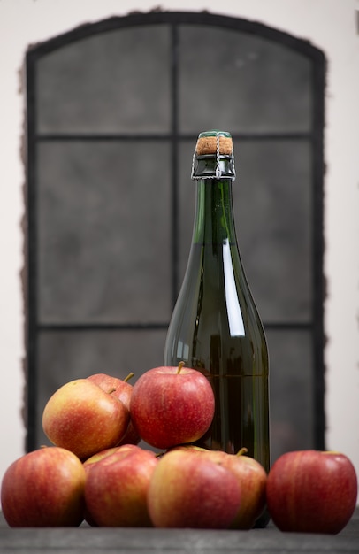 Botella de sidra y hermosas manzanas orgánicas.